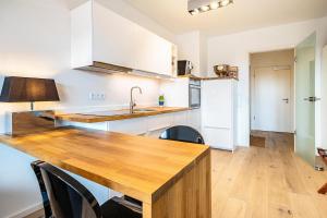 a kitchen with white cabinets and a wooden counter top at Weserloft 16 in Bremen