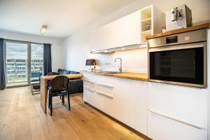 a kitchen with white cabinets and a table with a microwave at Weserloft 16 in Bremen