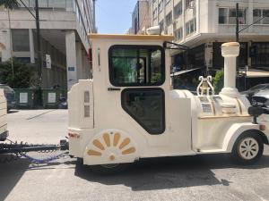 une petite voiture de train blanche garée dans une rue dans l'établissement Royal Blue Grand Suite No 2, au Pirée