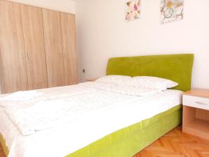 a bed with a green headboard in a bedroom at Vila Nikola in Soko Banja