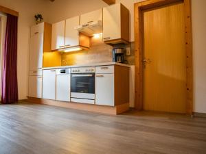 Il comprend une cuisine avec des appareils électroménagers blancs et du parquet. dans l'établissement Apartment Erna by Interhome, à Kappl