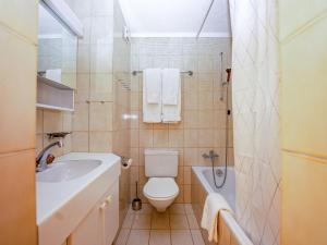 La salle de bains est pourvue de toilettes, d'une baignoire et d'un lavabo. dans l'établissement Apartment Chesa Pra d`Sura 217-10 by Interhome, à Maloja