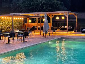 - une piscine avec des tables et des chaises et un pavillon dans l'établissement Prea Gianca, à Bonifacio