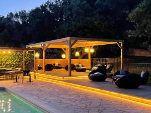 - une terrasse avec un pavillon et une piscine la nuit dans l'établissement Prea Gianca, à Bonifacio