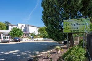 un cartel para un hotel en la esquina de una calle en Hôtel Restaurant Le Clos Charmant, en Vallon-Pont-dʼArc