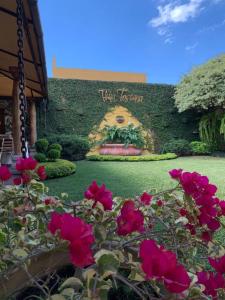 un cartello per un edificio con rose rosse in giardino di Hostal Villa Toscana a Guatemala