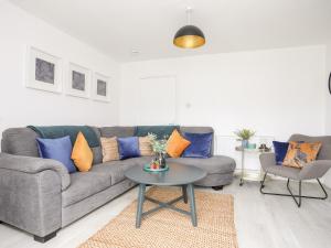 a living room with a couch and a table at Bwthyn Siliwen Old Bath House in Bangor