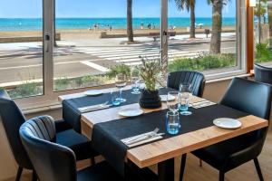 uma sala de jantar com uma mesa e vista para a praia em 4R Casablanca Playa em Salou