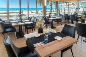 um restaurante com mesas e cadeiras e a praia em 4R Casablanca Playa em Salou