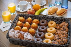 uma mesa coberta com um cesto de donuts e sumo de laranja em 4R Casablanca Playa em Salou