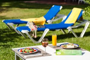 einen Tisch mit zwei Teller Essen und einem Glas Wein in der Unterkunft Apartamentos Turisticos Pinhal Da Marina in Vilamoura