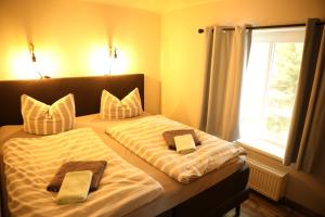 a bedroom with two beds with towels and a window at Seepavillon Rheinsberg in Rheinsberg