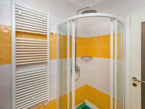 La salle de bains est pourvue d'une douche et de carrelage orange et blanc. dans l'établissement APARTMANI KRAJ, à Mošćenička Draga