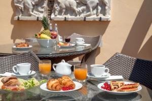 een tafel met een ontbijt van croissants en fruit bij Hotel Homs in Rome