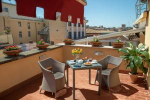 een patio met een tafel en stoelen op een balkon bij Hotel Homs in Rome