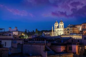 een skyline van de stad 's nachts met een kerk bij Hotel Homs in Rome