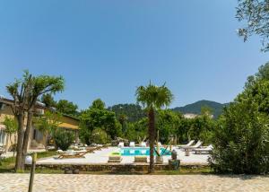 un complejo con piscina y palmeras en Natura Bungalows, en Limenas