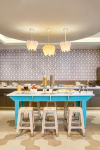 a kitchen with a blue table and stools at One Tapachula in Tapachula