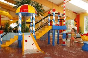 un niño pequeño jugando en un parque acuático en Sporthotel Neuruppin - Apartmenthaus mit Ferienwohnungen, en Neuruppin