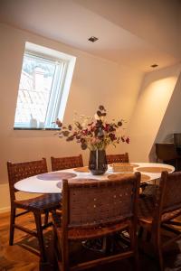 una mesa de comedor con un jarrón de flores. en Luxury apartment in Bergen's Gastronomic district, en Bergen