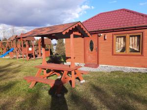 un tavolo da picnic in legno di fronte a una cabina di Agroturystyka nad Biebrza Sośniaki a Goniadz