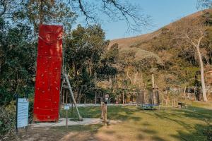 une structure rouge avec une échelle dans un parc dans l'établissement Hotel Vila Bavária Petrópolis, à Petrópolis