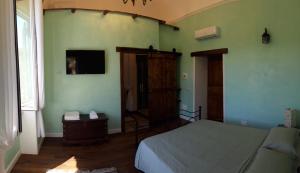 a bedroom with a bed and a tv on the wall at Villa Mazza al Vesuvio in Torre del Greco