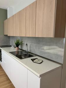 een keuken met witte kasten en een wastafel bij Costa Adriatica Apartments in Durrës