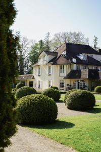 uma casa grande com arbustos à frente em Hostellerie De Levernois em Levernois