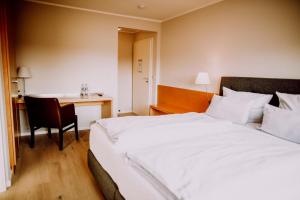 a hotel room with a bed and a desk at Romantik Hotel Schmiedegasthaus Gehrke in Bad Nenndorf