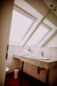 a bathroom with a sink and a skylight at Romantik Hotel Schmiedegasthaus Gehrke in Bad Nenndorf