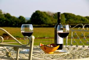 a bottle of wine and two glasses on a table at Fig Tree House in Penryn