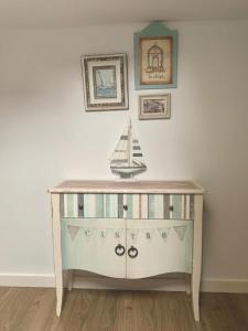 a wooden dresser with a toy boat on top of it at Precioso apartamento castro Urdiales in Castro-Urdiales