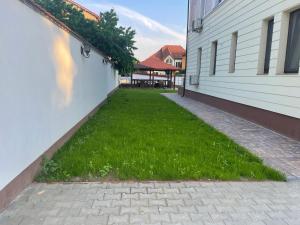 einen Garten mit Gras neben einem Gebäude in der Unterkunft Iarca Inn in Bukarest