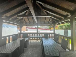 eine Terrasse mit Holztischen und -stühlen und einem Dach in der Unterkunft Iarca Inn in Bukarest