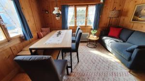 een woonkamer met een tafel en een bank bij Sonniges Chalet Arosa für 6 Pers alleinstehend mit traumhaftem Bergpanorama in Langwies