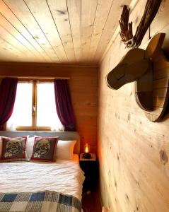 een slaapkamer met een bed in een houten kamer bij Sonniges Chalet Arosa für 6 Pers alleinstehend mit traumhaftem Bergpanorama in Langwies