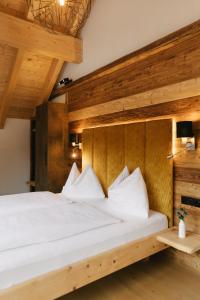 una camera da letto con un grande letto bianco e pareti in legno di SunApart by Apart4you a Haus im Ennstal