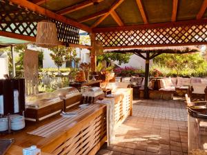 een openluchtrestaurant met een houten pergola bij Sunny Garden Aparthotel in Oud Epidauros