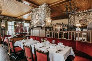 een restaurant met witte tafels en rode stoelen bij Hotel Alter Muschelsaal in Büsum