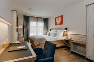 een hotelkamer met een bed en een bureau bij Hotel Alter Muschelsaal in Büsum