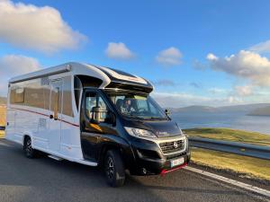 uma carrinha preta e branca a conduzir por uma estrada em Autocamper Tórshavn em Tórshavn