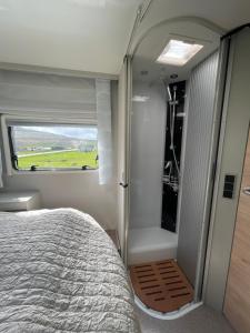 um quarto com uma cama e uma porta de vidro deslizante em Autocamper Tórshavn em Tórshavn