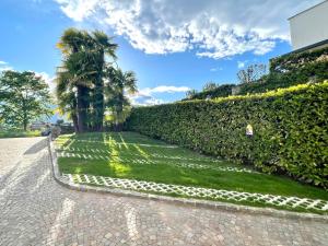 un jardín con setos y palmeras en Casa Alice Ascona, appartamento di vacanza., en Ascona