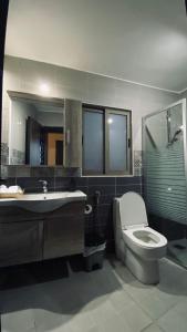 a bathroom with a toilet and a sink and a mirror at The Castle Star in Amman