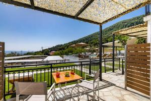 patio ze stołem i krzesłami na balkonie w obiekcie Panormos Beach Hotel Skopelos w mieście Panormos