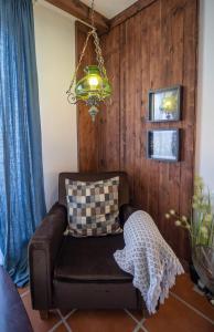 a living room with a couch and a chandelier at Beach House Babylon guest house with kitchenette and garden in Torreira