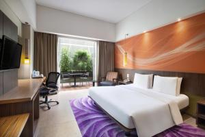 Pokój hotelowy z dużym łóżkiem i biurkiem w obiekcie Holiday Inn Bandung Pasteur, an IHG Hotel w mieście Bandung