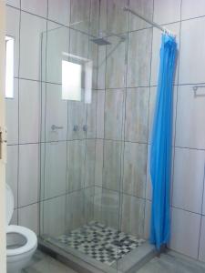 a shower with a blue shower curtain in a bathroom at Amariah Lodge in Kasane