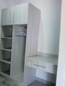 a closet with a wooden cabinet with at Amariah Lodge in Kasane